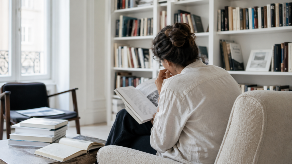 Personne consultant des documents dans un espace de lecture calme, pour illustrer la recherche et le discernement face à l’IA.